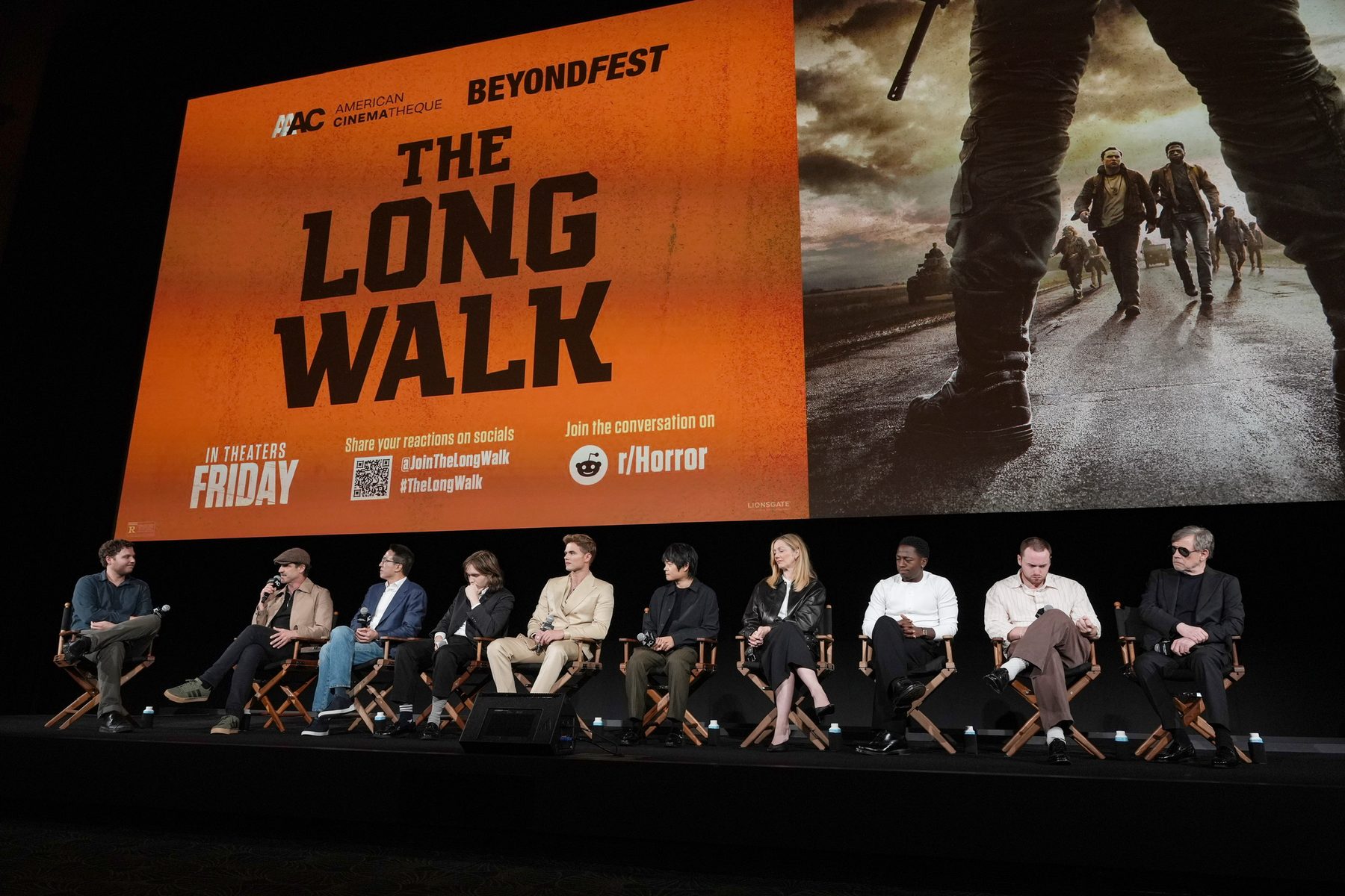 A festival panel on stage under a screening banner